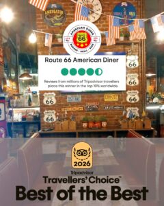 Brick-wall diner interior decorated with American flags and Route 66 signs; large sign says Route 66 American Diner with a Tripadvisor Travelers’ Choice 2026 badge in the foreground.